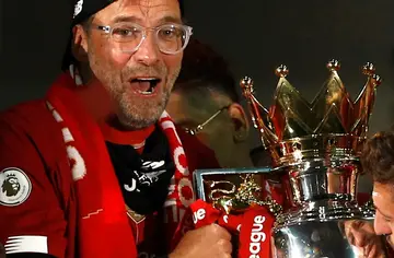 Jurgen Klopp clasps the Premier League trophy during the presentation after  playing Chelsea at an empty Anfield in July, 2020