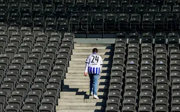 A Hertha Berlin supporter wearing the team's jersey leaves the Olympic Stadium in May after the team's relegation to the second division was confirmed