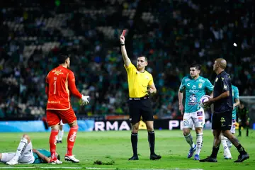 Referee Ismael Rosario Lopez shows a red card to goalkeeper Alfredo Talavera