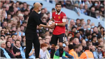 Pep Guardiola passes the ball to Bruno Fernandes during the Premier League match between Manchester City and Manchester United at Etihad Stadium. Photo by Matthew Ashton.