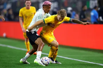 Riley McGree (R) of Australia tussles with Julian Araujo of Mexico during the first half of their friendly in Arlington, Texas on Saturday