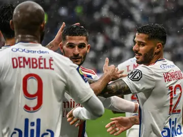 Houssem Aouar (C) celebrates with team mates after scoring a goal during the French L1 football match between Lyon and Montpellier