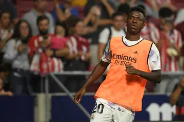 Vinicius Junior warms up in front of Atletico fans