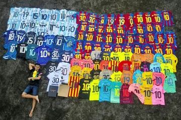 Surya Wijaya Ang poses with his collection of Lionel Messi jerseys in Banda Neira, Indonesia