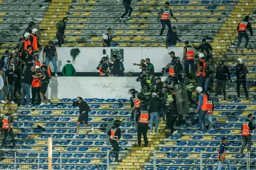 Police intervene among Raja fans during the CAF Champions League quarter-final football match between Morocco's Raja Casablanca and Egypt's Al Ahly at Mohammed V Stadium in Casablanca