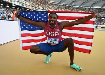Noah Lyles poses with the American flag after winning gold at the World Athletics Championships in Budapest, Hungary, on August 20..
