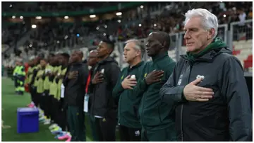 Hugo Broos and his staff during the National Anthem before the FIFA Series clash vs Algeria at the Nelson Mandela Stadium on March 26, 2024, in Algiers. Photo: Richard Pelham. 