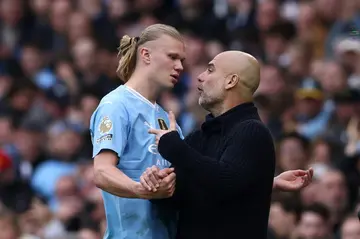 Manchester City manager Pep Guardiola speaks with Erling Haaland