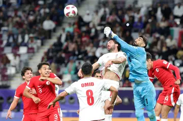 Iran's goalkeeper  Alireza Beiranvand leaps to clear the danger