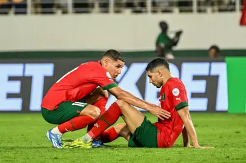 Achraf Hakimi (R) is consoled by his Morocco teammate Amine Harit after missing a crucial late penalty in his team's 2-0 defeat to South Africa