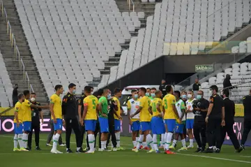 Brazilian health officials talk to players after halting a World Cup qualifier against Argentina
