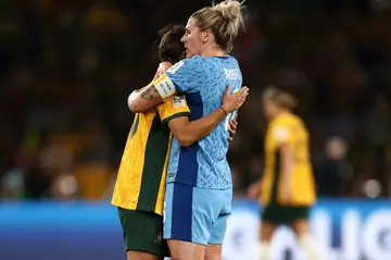 England defender Millie Bright (R) embraces Australia's forward Sam Kerr