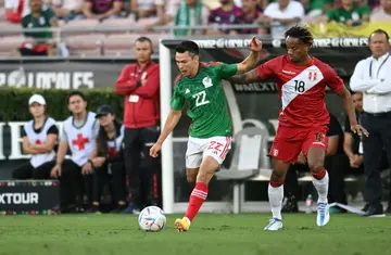 Mexico forward Hirving Lozano vies for the ball with Peru midfielder André Carrillo in Mexico's 1-0 victory in a friendly international football match at the Rose Bowl
