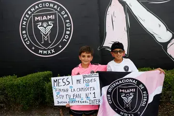 Young fans hold a sign asking Lionel Messi to sign their shirt outside DRV PNK Stadium in Fort Lauderdale, Florida, where the Argentine star was to be presented as the newest player for Major League Soccer's Inter Miami