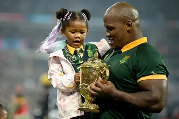 Bongi Mbonambi celebrates with his daughter following the team’s victory in the Rugby World Cup Finals