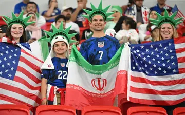Fans hold the flags of the USA and Iran before the World Cup match at the Al-Thumama Stadium in Doha