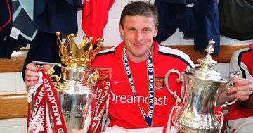 Oleg Luzhny of Arsenal with the Premier League trophy and the FA Cup Trophy after the match between Arsenal and Everton on May 11, 2002 in London, England. (Photo by Stuart MacFarlane/Arsenal FC via Getty Images)