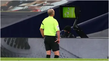 Referee Mike Dean checks the VAR pitchside monitor during the Premier League match between Tottenham Hotspur and Manchester City. Photo by Clive Rose.
