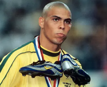 The Brazilian star striker Ronaldo wears his tied football boots around his neck at the end of the game