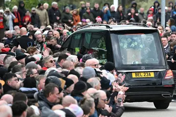 A hearse carrying the coffin of Bobby Charlton is driven past Old Trafford