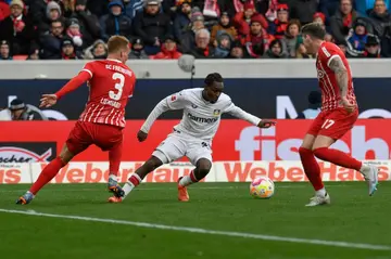 Leverkusen defender Jeremie Frimpong, centre, battles it out with the Freiburg defence. Frimpong has been in top form for Leverkusen