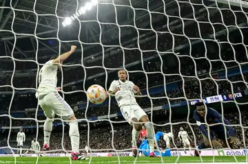 Real Madrid defender Eder Militao (C) reacts after scoring an own goal against Barcelona
