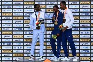 Noah Lyles is comforted by Letsile Tebogo and Zharnel Hughes after receiving his men's 100m gold medal at the World Athletics Championships on August 21.