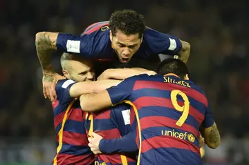 Dani Alves jumps on the pile congratulating goal scorer Lionel Messi as Barcelona beat River Plate  in the Club World Cup football final in Yokohama in 2015