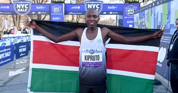 Rhonex Kipruto celebrates as he crosses the finish line during the 2022 United Airlines NYC Half Marathon on March 20, 2022 in New York City. Photo by Bryan Bedder.