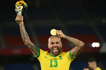 Dani Alves showing off the last addition to his collection of trophies as he receives his Olympic gold medal in Yokohama