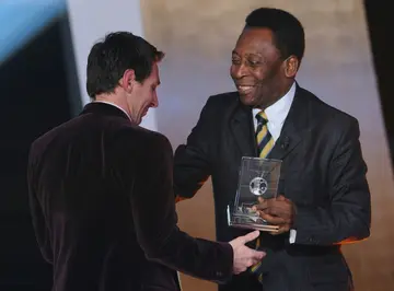 Hand it over: Lionel Messi receives a FIFA World XI award from Pele in 2012