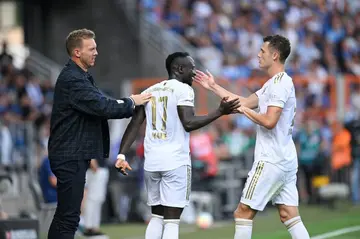 Bayern Munich coach Julian Nagelsmann (L) and defender Benjamin Pavard (R) congratulate Sadio Mane after his first goal against Bochum