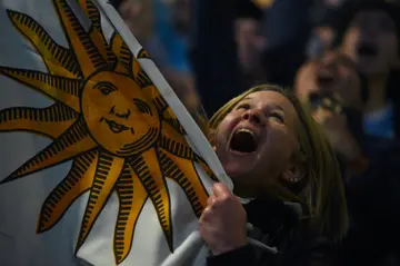 A fan celebrates after watching Uruguay  win the Under-20 World Cup, on a giant screen outside Montevideo's City Hall