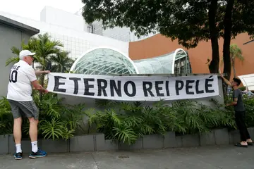 Fans of Brazilian football legend Pele with a banner reading "Eternal King Pele" outside the Albert Einstein Israelite Hospital