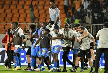 DR Congo goalkeeper Lionel Mpasi is held aloft by his teammates after scoring the winning penalty in the shoot-out against Egypt