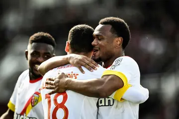 Alexis Claude Maurice (C) receives a hug from Lois Openda after completing the scoring as Lens won at Clermont