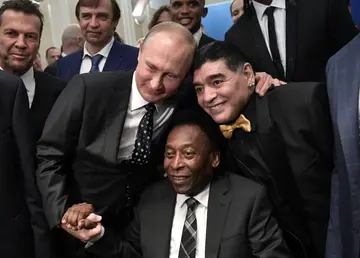 Borrowed aura: Vladimir Putin joins Pele and Diego Maradona as they pose ahead of the World Cup draw in Moscow in 2017