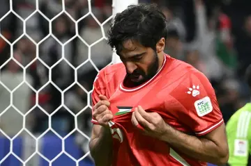 Palestine's defender  Mohammed Saleh looks at his jersey