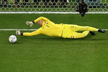 Poland goalkeeper Wojciech Szczesny dives to stop a penalty by Saudi Arabia's Salem Al-Dawsari