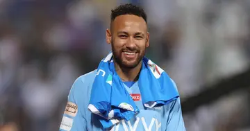 Neymar smiling in Al-Hilal shirt.