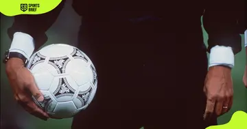A referee holds a ball.