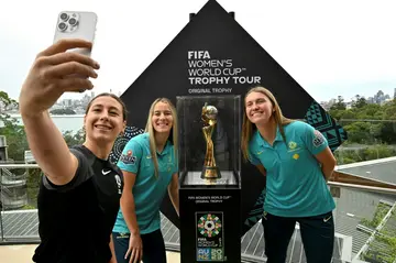 Australia's Sarah Hunter, Courtney Nevin and Clare Hunt (l-r) pose with the Women's World Cup trophy in Sydney