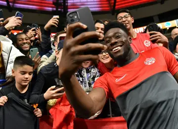 Man of the people: Davies takes a selfie with fans after a CONCACAF Nations League game in June