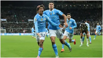 Oscar Bobb celebrates with Rodri after scoring during the Premier League match between Newcastle United and Manchester City at St. James' Park. Photo by Simon Stacpoole.