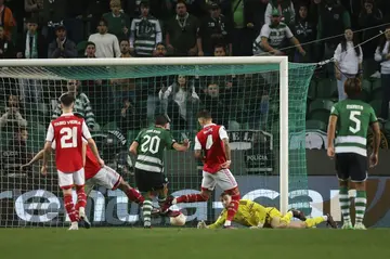 Sporting Lisbon's Paulinho (C) scores his team's second goal in the 2-2 draw with Arsenal on Thursday