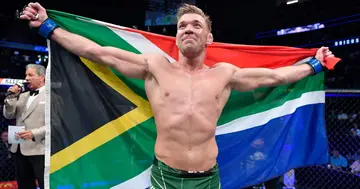 Dricus du Plessis celebrates with the South African flag after UFC win.