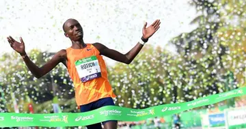 Kenya's Elisha Rotich celebrates on the finish line as he wins the men's race in the 42,195 km Paris Marathon, as part of its 45th edition on October 17, 2021. (Photo by Alain JOCARD / AFP) (Photo by ALAIN JOCARD/AFP via Getty Images)