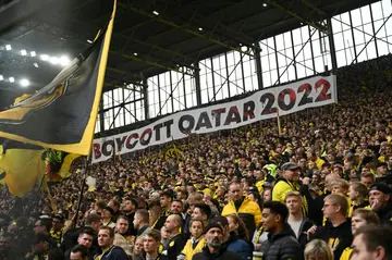 Dortmund fans in the club's famous 'yellow wall' hold up a banner reading "#Boycott Qatar 2022"
