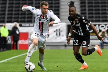 Aaron Ramsey (L) runs past Angers defender Souleyman Doumbia in Ligue 1