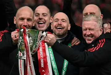 Manchester United manager Erik ten Hag (C) and his assistants celebrate with the League Cup trophy